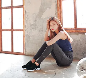 Woman sitting in gym gear wearing black air-cushioned running sneakers