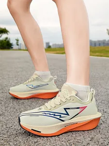Gros plan de chaussures de course crème ultralégères avec semelles orange épaisses