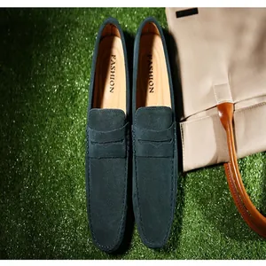 Vista superior detallada de mocasines de ante azul oscuro para hombre sobre fondo verde
