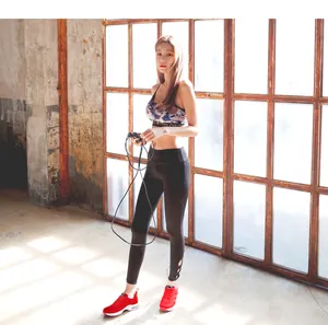 Women's red running sneakers shown in a lifestyle fitness setting with a model