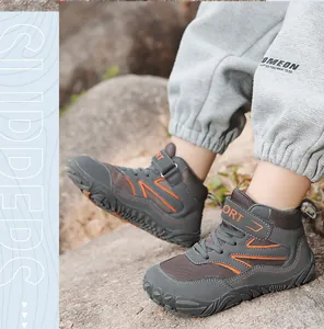 Gedetailleerd overzicht van halfhoge outdoor wandelschoenen voor kinderen op rotsachtig terrein