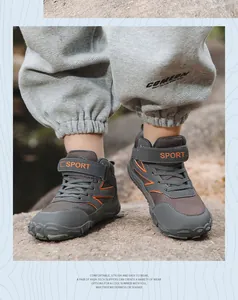 Detailopname van grijze outdoor wandelschoenen voor kinderen met oranje SPORT-band
