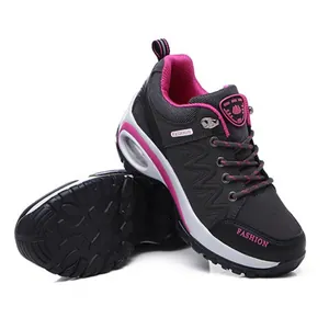 Detalle de vista lateral de zapatillas de senderismo grises y rosa con suela de aire