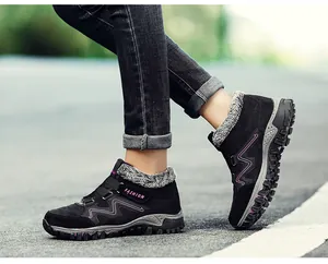 Close-up detail of black outdoor winter boots with warm purple accents and fur lining