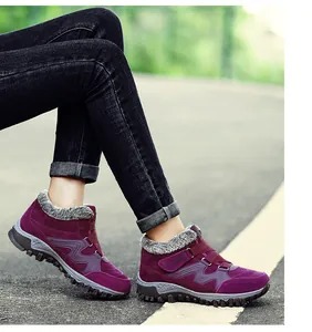 Close-up of purple winter thermal outdoor shoes with faux fur lining on a scenic road path