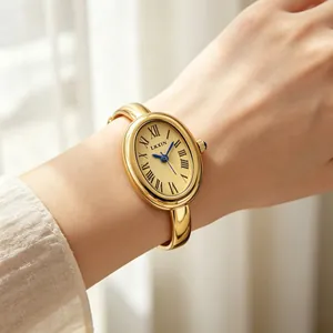 Macro detail view of an elegant oval gold bangle watch with blue hands and Roman dial.