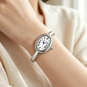 Close-up of a elegant oval silver bangle watch with Roman numerals on a woman's wrist