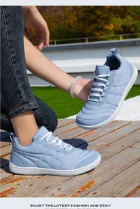 Vista detallada de zapatillas casuales acolchadas azul claro en una plataforma de madera rústica