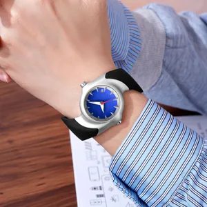 Close-up of a silver distorted Y2K watch with a blue dial worn on a person's wrist