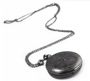 Macro view of the intricate engraved pattern on a vintage black metal pocket watch