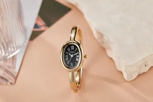 Elegante vintage ovale goudkleurige armbandhorloge met Romeinse cijfers op zwart.
