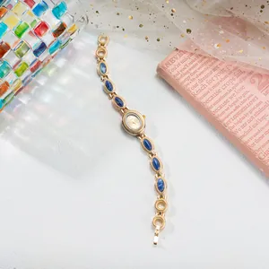 Détail d'une montre bracelet vintage en or avec incrustations de pierres bleues chic.
