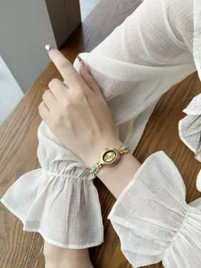 Montre-bracelet vintage en or pour femme avec pierres turquoises au poignet