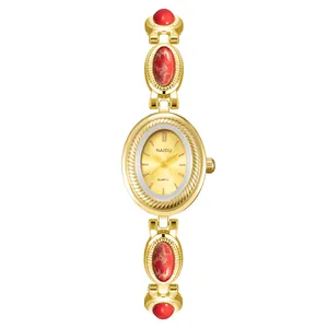 Montre-bracelet vintage dorée pour femme avec incrustations de pierres rouges