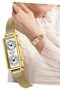 Élégante montre à quartz rectangulaire dorée pour femme avec double fuseau horaire au poignet.