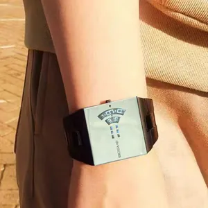 Gros plan d'une montre à quartz carrée élégante avec un affichage numérique unique.