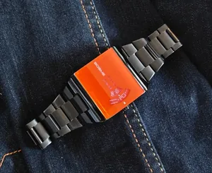 Détail d'une montre à quartz pour homme avec cadran orange carré et bracelet noir en métal