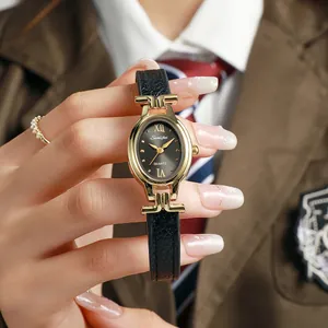 Close-up of elegant women's oval quartz watch with black leather strap and gold case