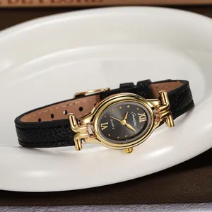 Close-up of an elegant oval women's quartz watch with a gold-toned case and black strap.