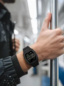 Gros plan de la montre de sport numérique noire TOMI portée au poignet en ville