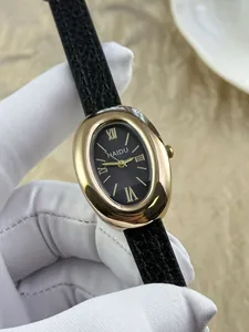 Close-up van een prachtig vintage ovaal goudkleurig horloge met zwart lederen band