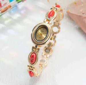 Élégante montre bracelet dorée de style vintage avec cadran ovale et pierres rouges