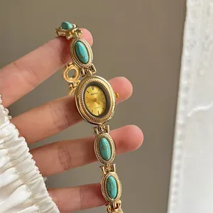 Vue détaillée d'une montre-bracelet dorée vintage avec des pierres turquoises élégantes