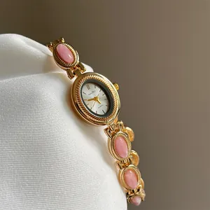 Montre-bracelet élégante vintage dorée pour femme avec pierres roses et mouvement quartz