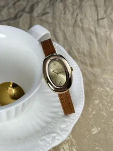 Gedetailleerde close-up van een elegant vintage ovaal goud horloge met leren band.