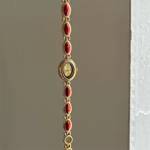 Vue détaillée d'une montre bracelet vintage en or avec d'élégantes incrustations rouges