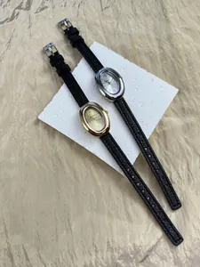 Detailopname van elegante vintage ovale horloges in goud en zilver met zwarte leren band.