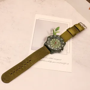 Dettaglio di un orologio al quarzo da uomo in stile militare con un cinturino in nylon.
