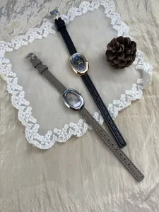 Twee vintage ovale dameshorloges met leren bandjes op een decoratief kanten kleedje