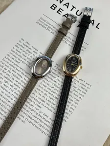 Detailopname van elegante vintage ovale horloges met lederen bandjes en Romeinse cijfers