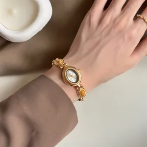 Gros plan détaillé d'une montre vintage dorée pour femme avec bracelet en pierre