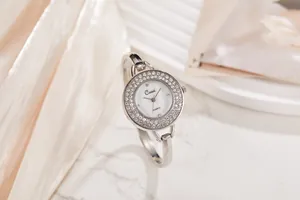 Primo piano di un elegante orologio a bracciale argentato con quadrante rotondo di cristalli.
