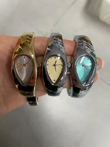 Nahaufnahme von drei Y2K-Armbanduhren in Tropfenform in Gold- und Silberoptik für Damen