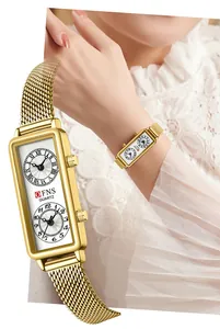 Détail d'une montre à quartz pour femme à double fuseau horaire avec bracelet doré.