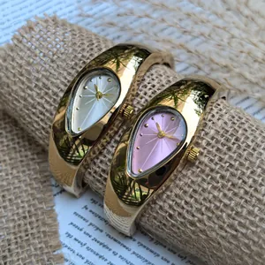 Gros plan de montres bracelets Y2K dorées en forme de larme avec cadrans colorés