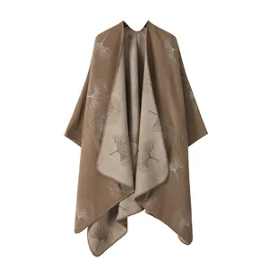Detailed view of a brown and beige faux cashmere knit poncho with ginkgo leaf patterns
