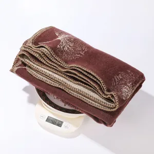 Macro view of a maroon faux cashmere shawl on a scale showing its weight details