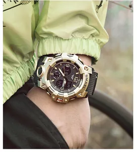 Macro view of SMAEL 8008 gold and black sports watch worn on wrist outdoors