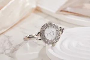 Primo piano di orologio a bracciale in argento con ghiera di strass e quadrante