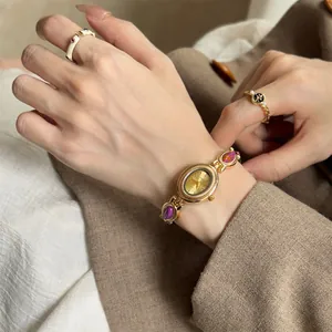 Gros plan d'une montre-bracelet dorée de luxe vintage au poignet d'une femme