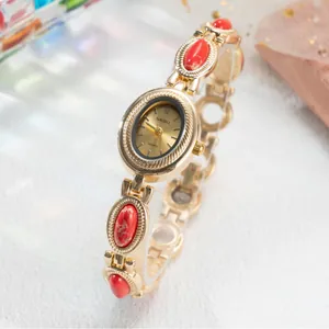 Montre bracelet dorée vintage pour femme avec accents de pierres rouges et quartz