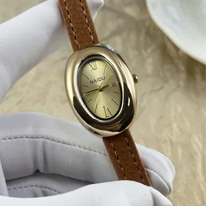 Elegante vintage ovaal dameshorloge met een goudkleurige kast en bruine lederen band