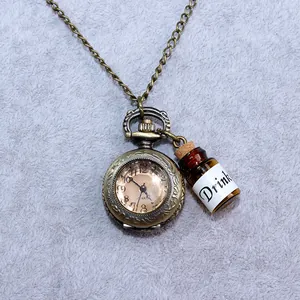 Detailansicht einer Vintage-Taschenuhr-Halskette mit kleinem 'Drink'-Flaschenanhänger.