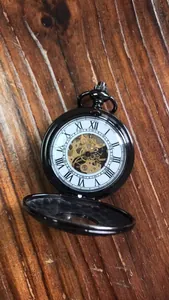 Dettaglio macro di un orologio da taschino meccanico nero vintage con numeri romani