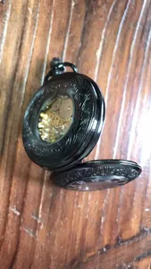 Dettaglio macro di un orologio da tasca meccanico nero vintage con intricato design a ingranaggi