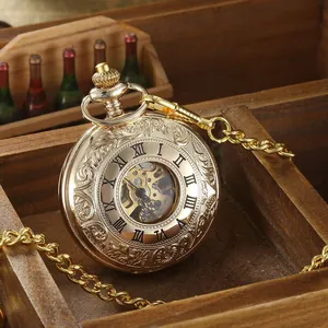 Gros plan d'une montre de poche mécanique vintage dorée avec gravures florales ajourées